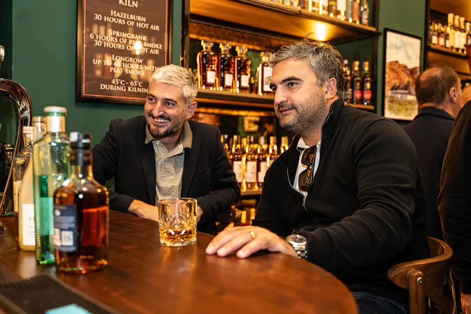 Guests with whisky at the wooden bar of BARD Whisky Bar, Tbilisi