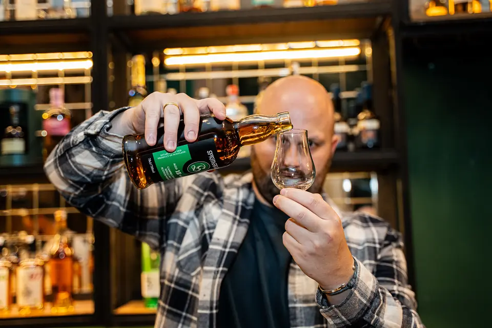 Pouring Springbank whisky into a tasting glass at BARD Whisky Bar, Tbilisi